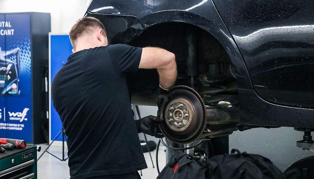Mekaanikko huoltaa auton jarruja korjaamolla