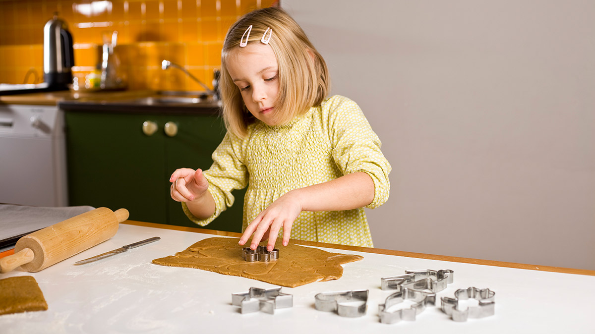 Joulu, tyttö leipoo pipareita.