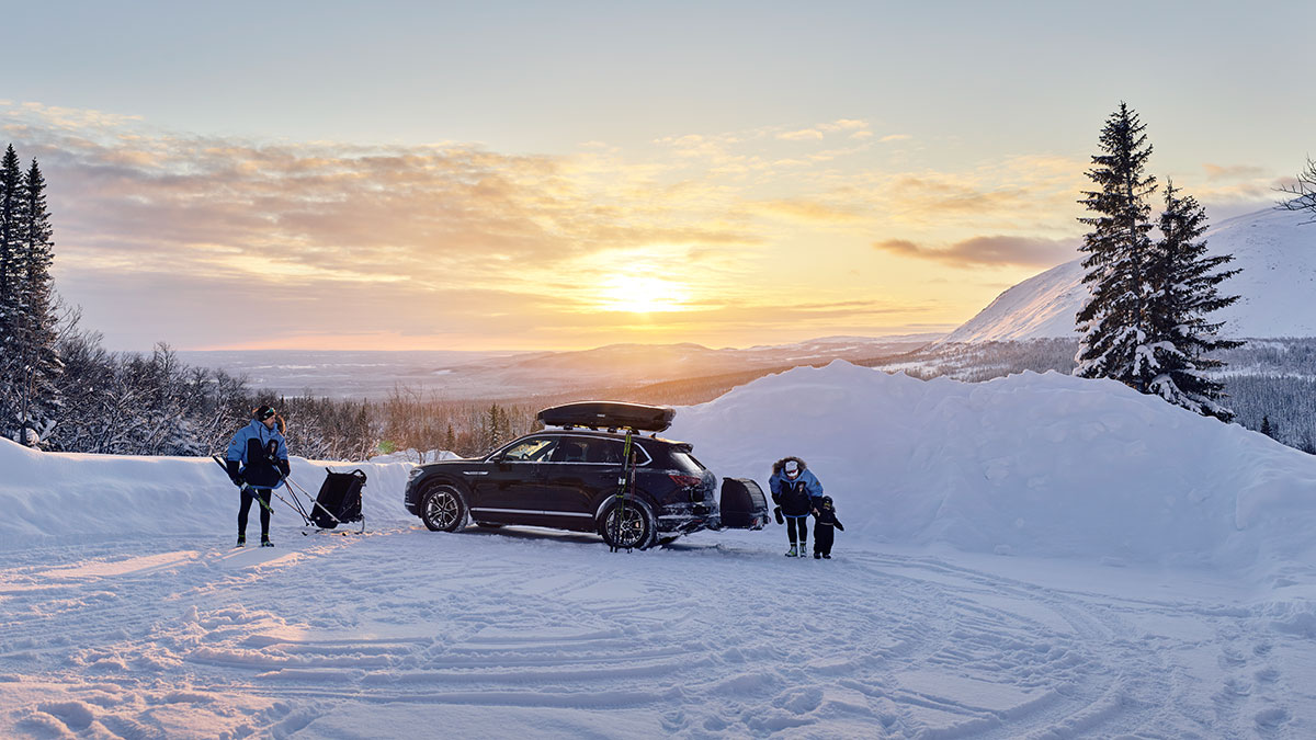 Perhe tunturissa. Autossa Thule-suksiboksi ja -kuljetuslaatikko.